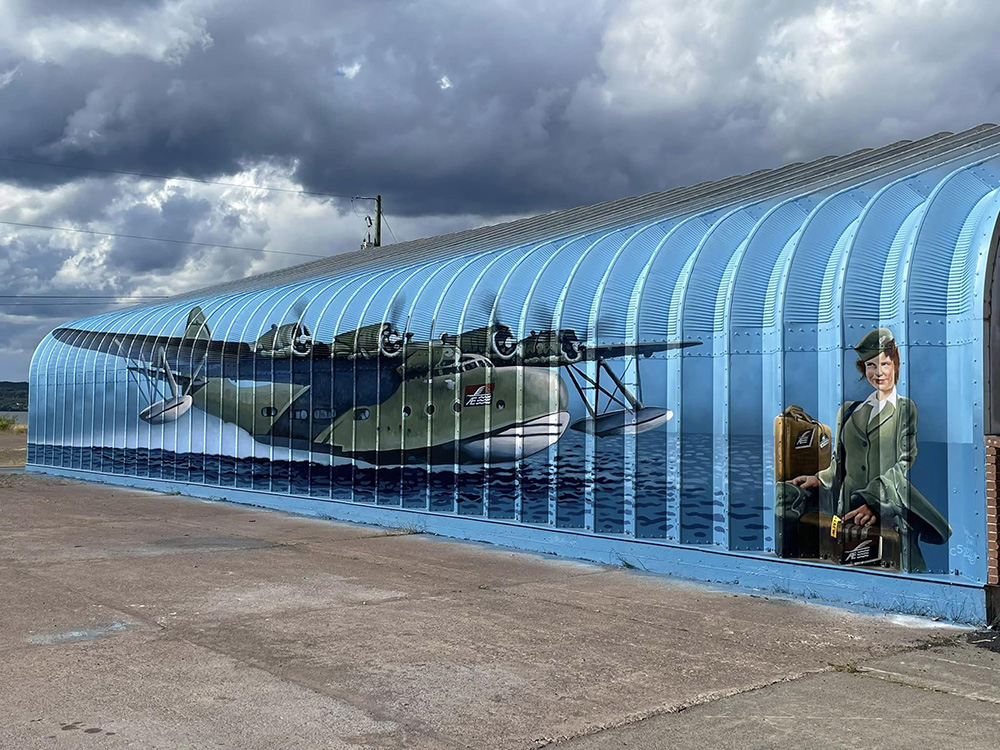 A mural of a wartime airplane and a woman dressed in a military uniform.
